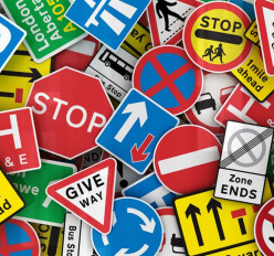 What is taken into account when making a road sign design?